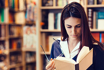 A female reading a booking in a library