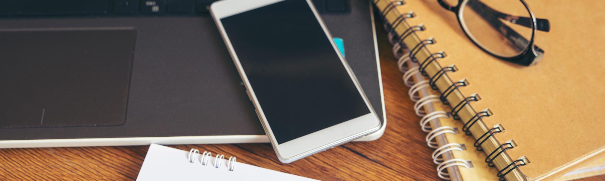 Laptop, smartphone and stationery on desk